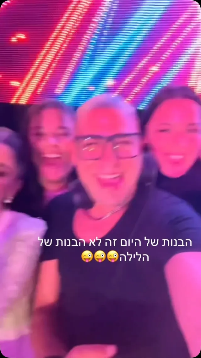 אורחים מצטלמים ברחבת אירוע מול מסך צבעוני